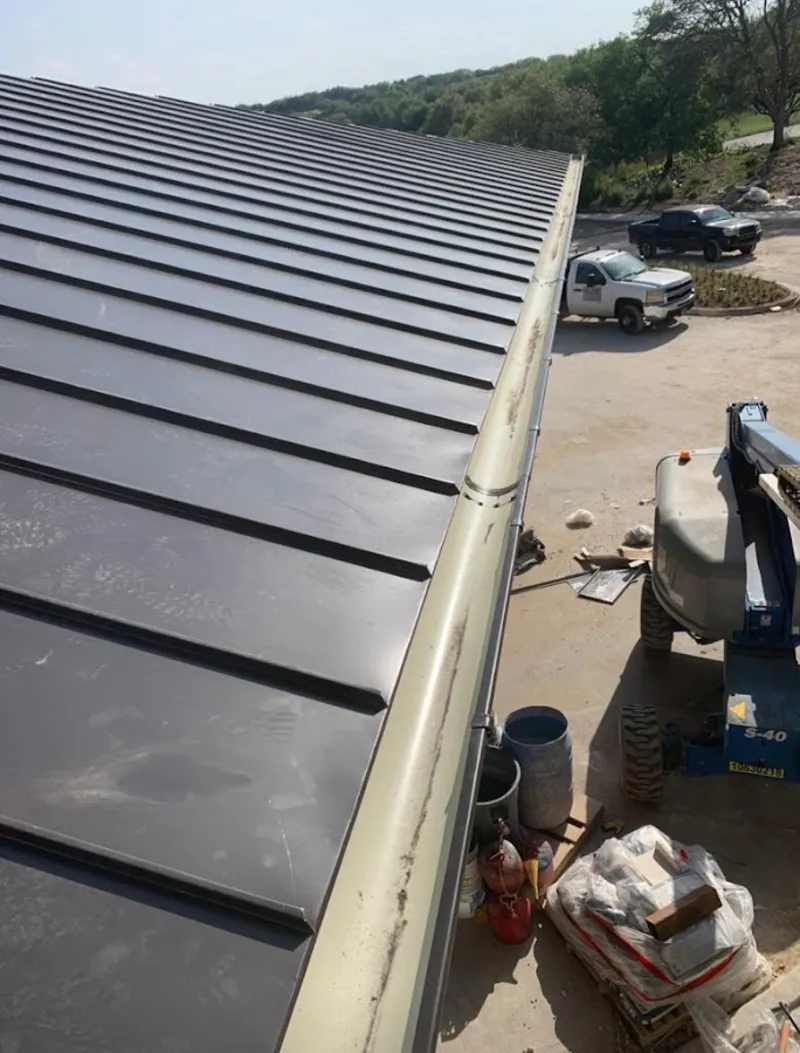 Standing seam panel and gutter detail on a metal roofing jobsite in Powder Springs